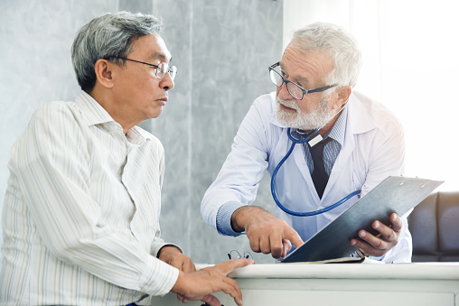 Senior male Doctor is discussing with male patient.